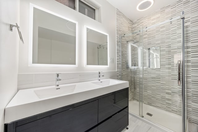 bathroom featuring vanity, a shower with shower door, and tile walls