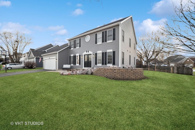 view of front of home featuring an attached garage, a front lawn, fence, and aphalt driveway