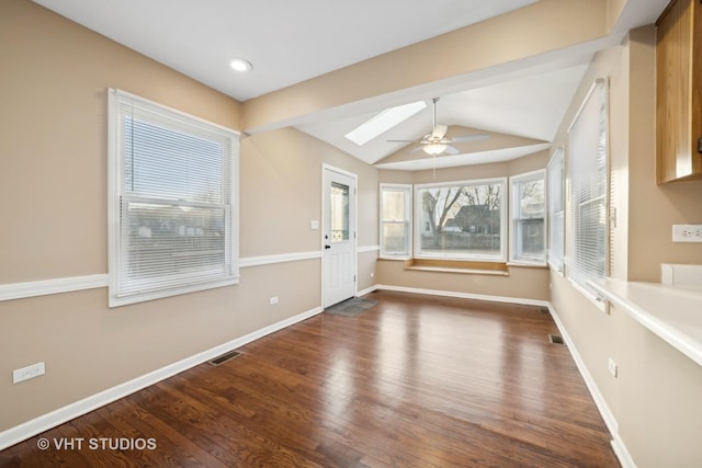 interior space featuring ceiling fan, wood-type flooring, and vaulted ceiling with skylight