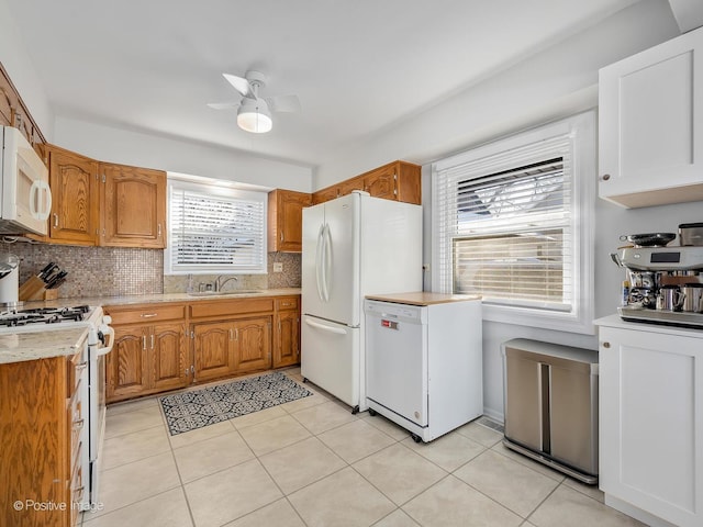 kitchen featuring sink, white appliances, light tile patterned floors, ceiling fan, and decorative backsplash