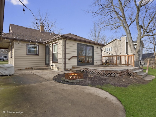 rear view of property featuring a wooden deck and a patio area