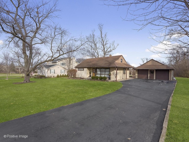 view of front of property featuring a garage, an outbuilding, and a front yard