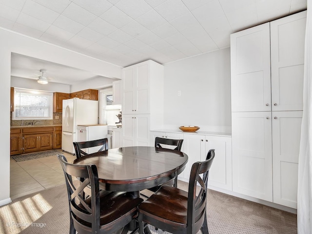 tiled dining space with sink and ceiling fan