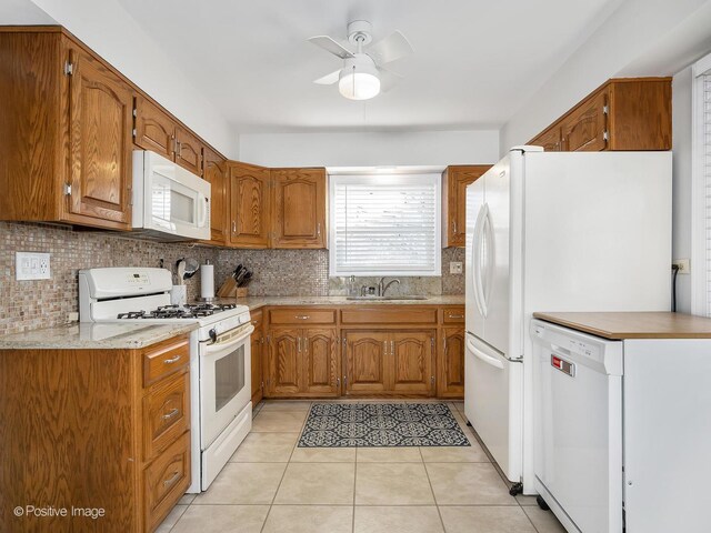 kitchen with backsplash, white appliances, sink, and light tile patterned floors