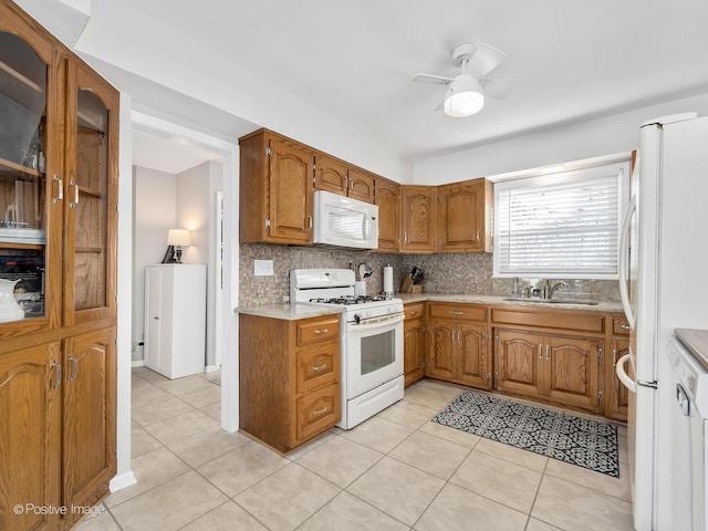 kitchen with light tile patterned flooring, sink, backsplash, ceiling fan, and white appliances