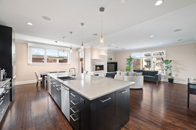 kitchen featuring sink, dark hardwood / wood-style flooring, hanging light fixtures, stainless steel dishwasher, and a spacious island