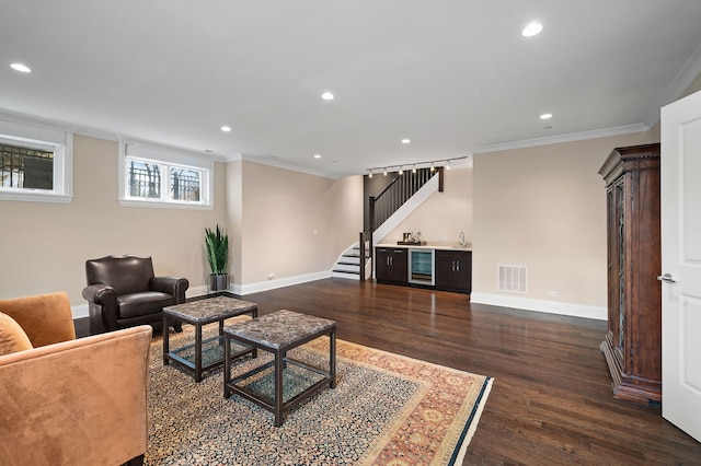 living room featuring crown molding, dark wood-type flooring, beverage cooler, and indoor bar