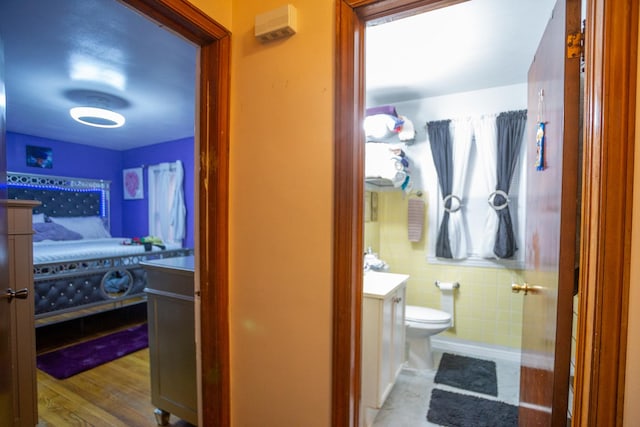 bathroom with vanity, hardwood / wood-style flooring, tile walls, and toilet