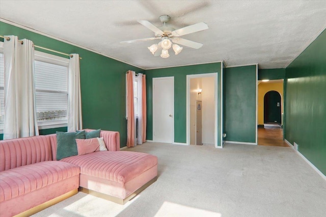 living room featuring ornamental molding, ceiling fan, and carpet flooring