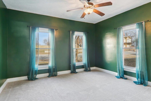 carpeted spare room with ceiling fan