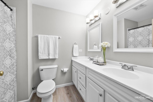 bathroom featuring vanity, wood-type flooring, and toilet