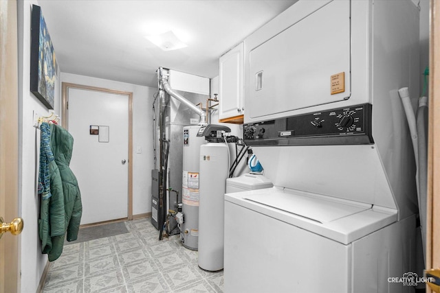 clothes washing area featuring stacked washer and dryer, gas water heater, and cabinets