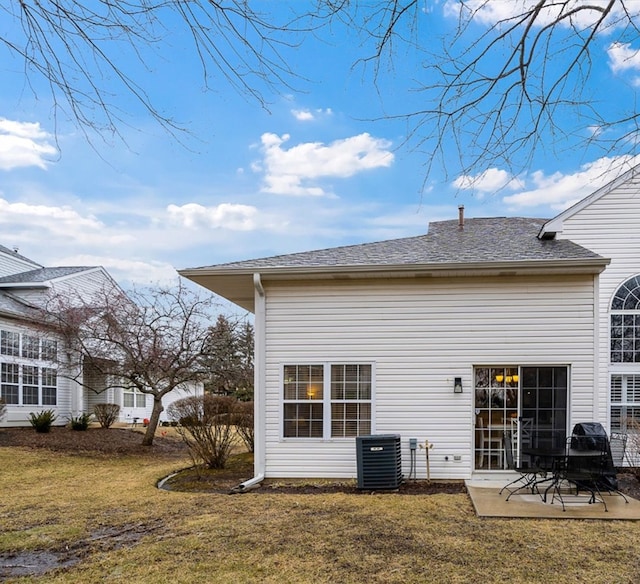 rear view of property with central AC unit, a yard, and a patio area