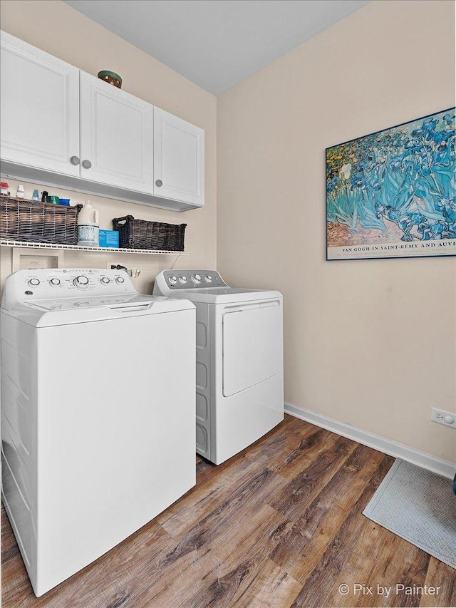 clothes washing area with separate washer and dryer, dark hardwood / wood-style floors, and cabinets