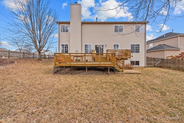 rear view of house with a deck and a lawn