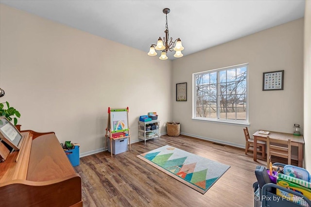 playroom featuring hardwood / wood-style flooring and a notable chandelier