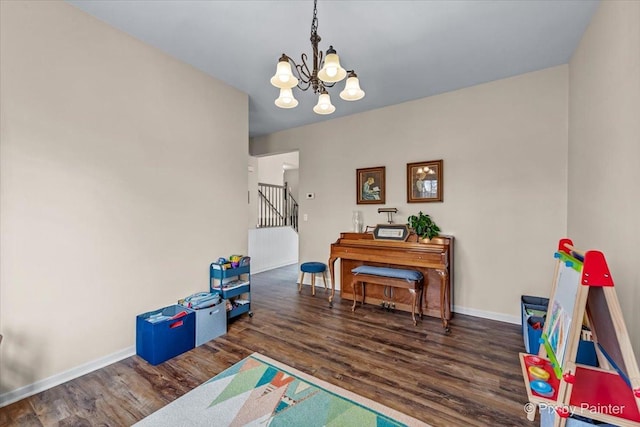 recreation room featuring dark wood-type flooring and a notable chandelier