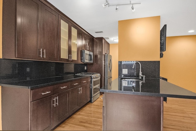 kitchen with tasteful backsplash, sink, a kitchen bar, light hardwood / wood-style floors, and stainless steel appliances