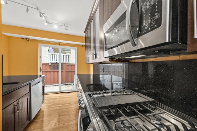 kitchen featuring stainless steel appliances, dark brown cabinets, and light hardwood / wood-style flooring