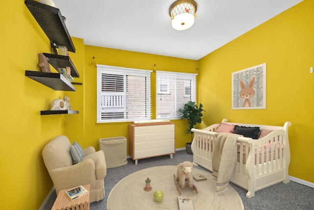 carpeted bedroom featuring a nursery area