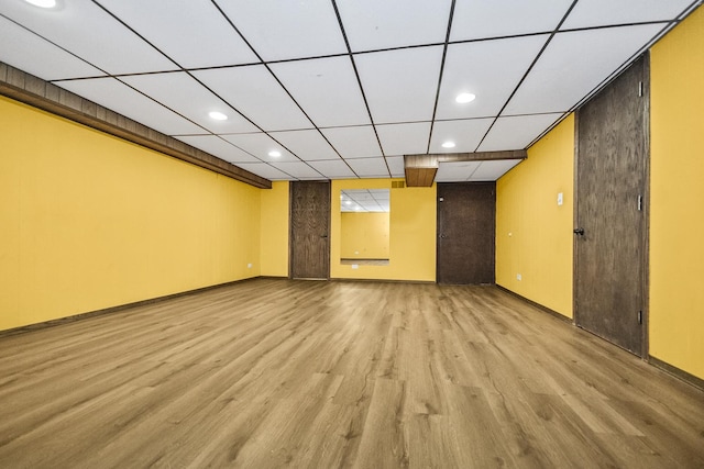 empty room featuring a paneled ceiling and light wood-type flooring