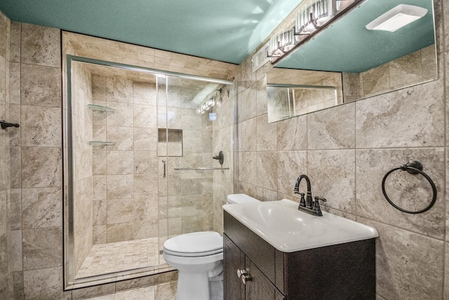 bathroom featuring vanity, toilet, tile walls, and walk in shower