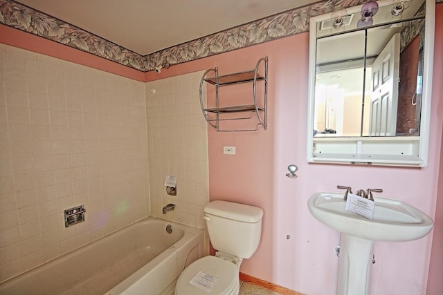 bathroom with toilet and tiled shower / bath combo