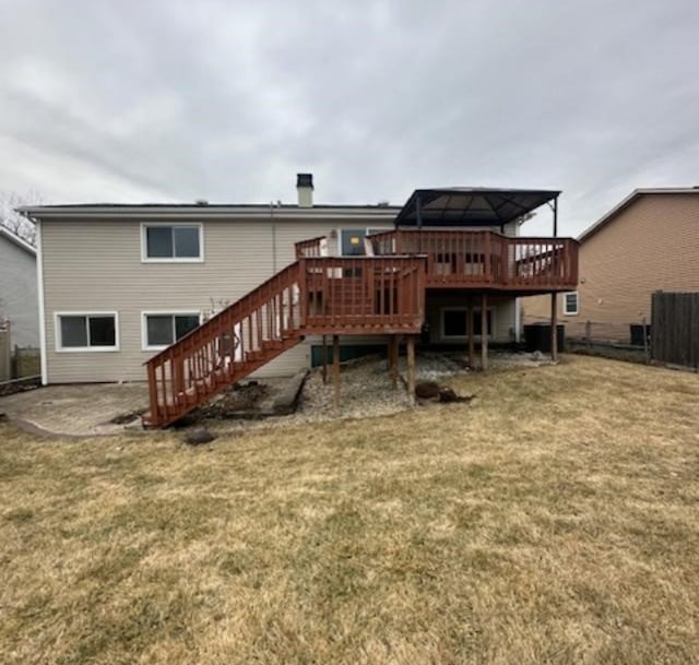 rear view of property featuring a wooden deck, a yard, and a gazebo