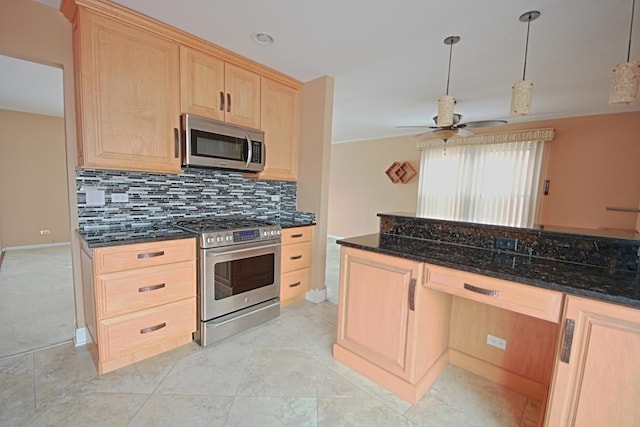 kitchen featuring appliances with stainless steel finishes, light brown cabinets, and dark stone counters