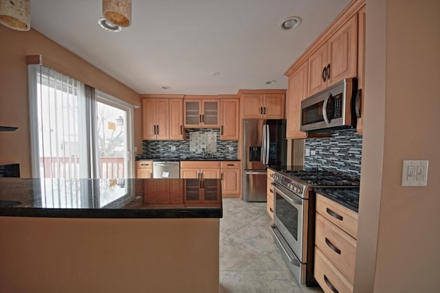 kitchen featuring light brown cabinetry, sink, backsplash, kitchen peninsula, and stainless steel appliances