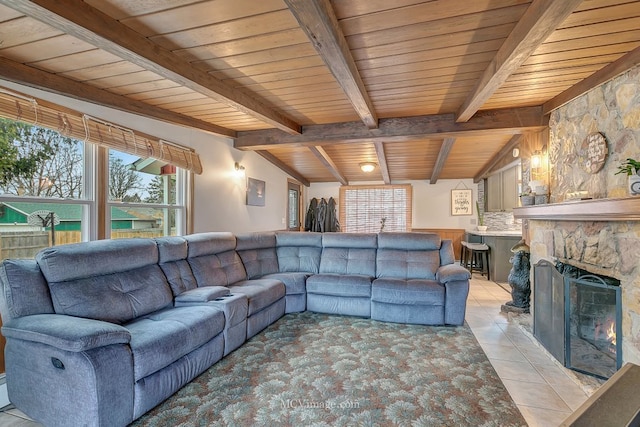 tiled living room featuring vaulted ceiling with beams, a fireplace, and wooden ceiling