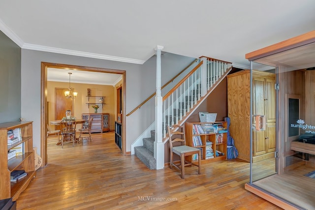 staircase with crown molding, wood-type flooring, and a chandelier