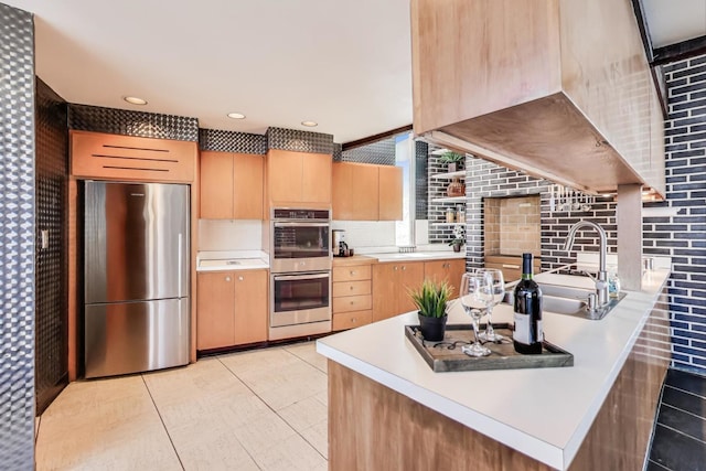 kitchen with light tile patterned floors, stainless steel appliances, light countertops, decorative backsplash, and light brown cabinetry