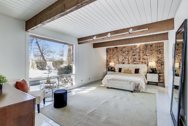 bedroom featuring beamed ceiling and baseboards