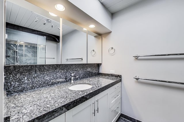 full bath featuring a stall shower, vanity, and decorative backsplash