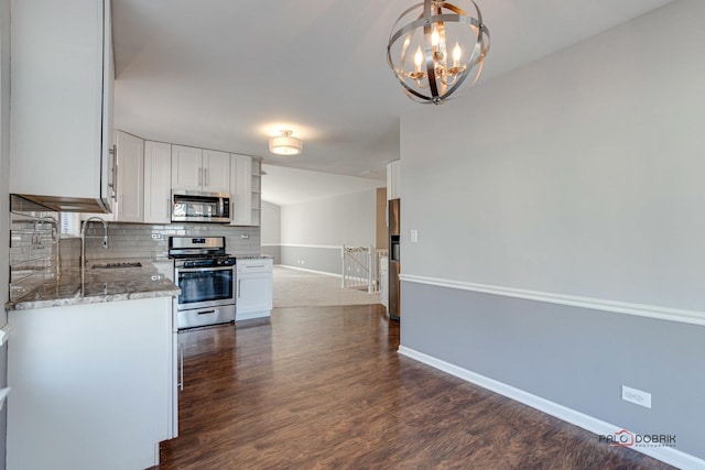 kitchen featuring stainless steel appliances, white cabinetry, sink, and decorative backsplash