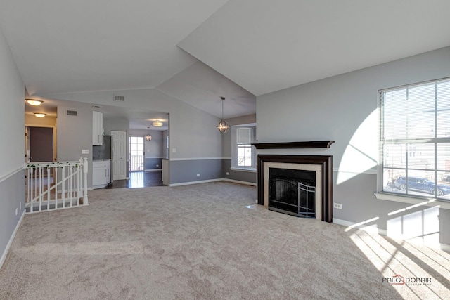 unfurnished living room featuring light colored carpet, lofted ceiling, and a fireplace