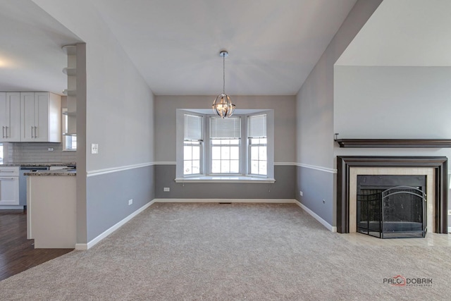 unfurnished living room featuring light carpet and a notable chandelier