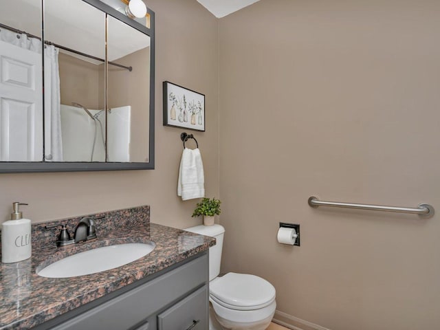 bathroom featuring vanity, toilet, and walk in shower