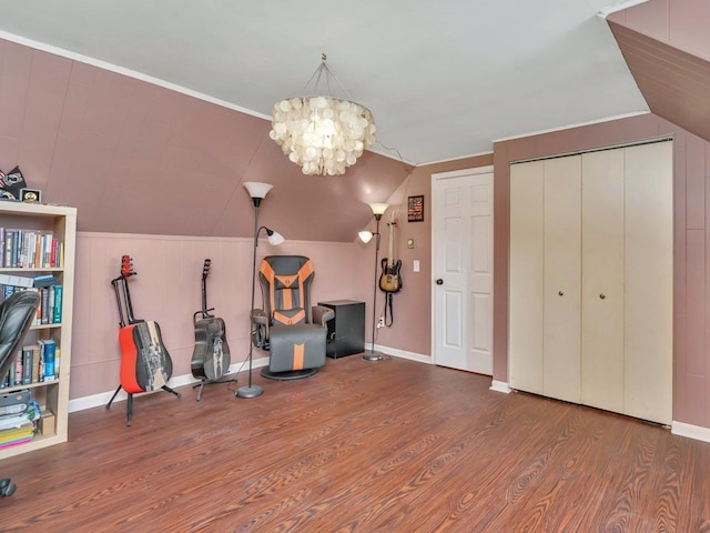 miscellaneous room featuring wood-type flooring, lofted ceiling, and a chandelier