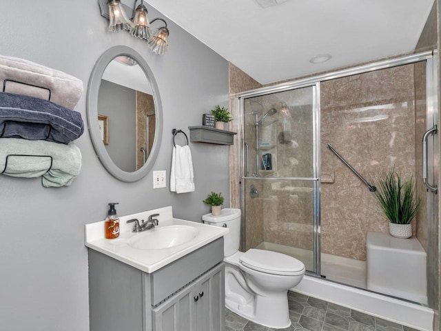 bathroom featuring vanity, an enclosed shower, and toilet