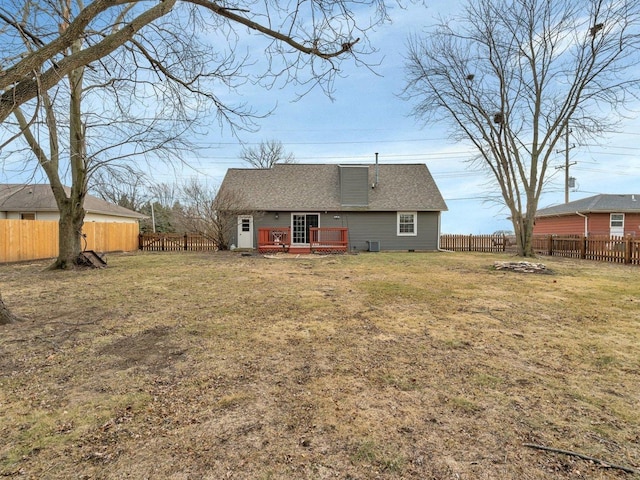 rear view of house featuring a lawn and a deck