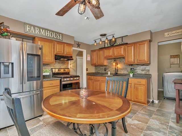 kitchen with sink, appliances with stainless steel finishes, ceiling fan, washer / clothes dryer, and backsplash