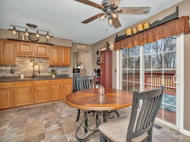 dining space featuring ceiling fan and sink