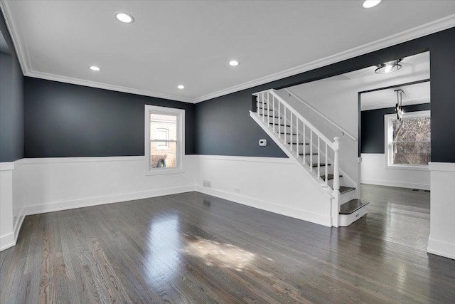 spare room featuring dark hardwood / wood-style flooring, crown molding, and plenty of natural light