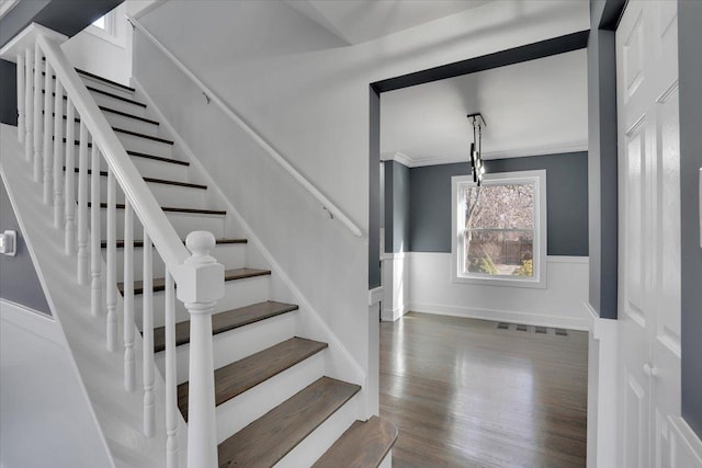 staircase featuring hardwood / wood-style flooring and crown molding