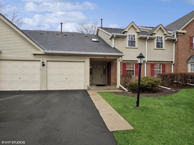 view of front of house featuring aphalt driveway, an attached garage, brick siding, roof with shingles, and a front yard