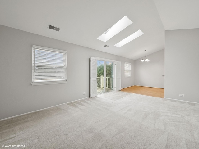 spare room with lofted ceiling, visible vents, and carpet flooring