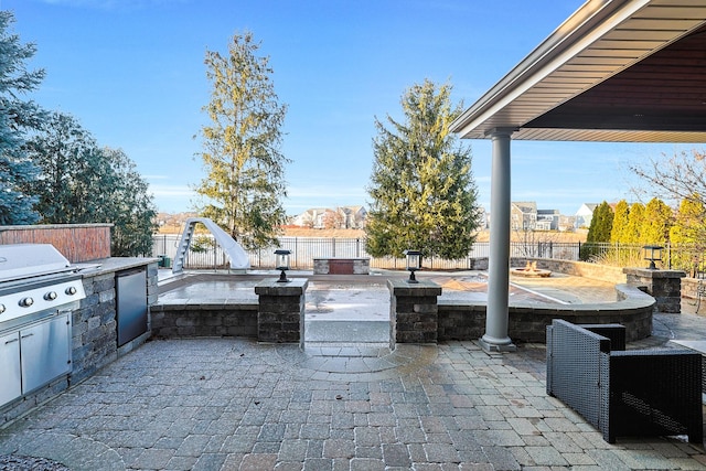 view of patio with a fenced backyard, grilling area, and exterior kitchen