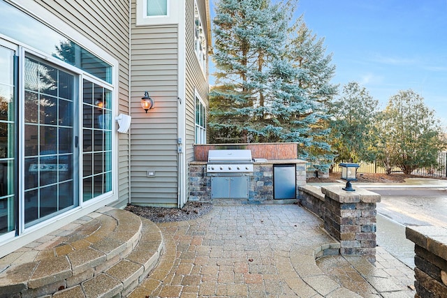 view of patio with exterior kitchen, fence, and area for grilling